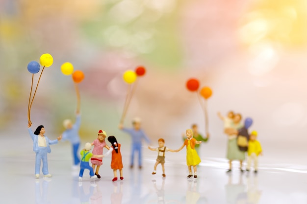 Miniature people, family and children with colorful balloons, Family concept.