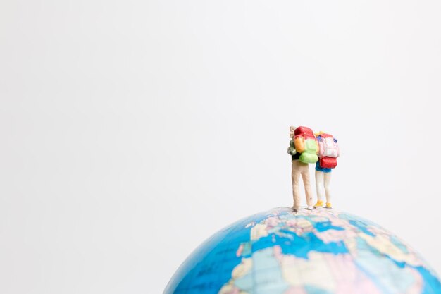 Photo miniature people figure standing on the globe world map