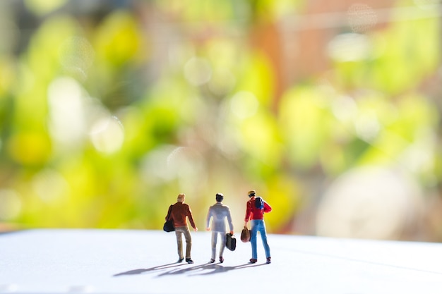 Miniature people group of man on travel action using as business concept