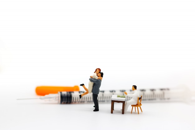 Miniature people: Lover meet doctor with syringe. Health care concept.