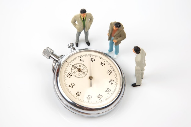 Miniature people mechanical stopwatch on the background of business people Part time accuracy for business business and finance time