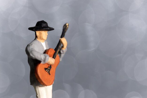 Miniature people Musician with guitar on bokeh background