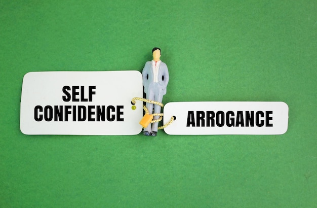 miniature people and paper with two choice words self confidence or arrogance