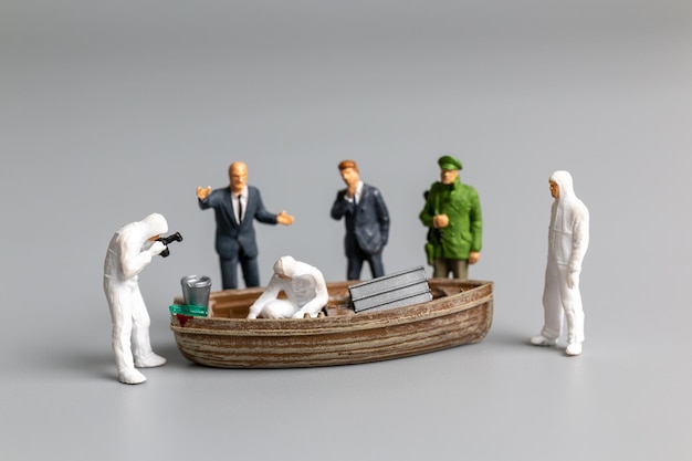 Photo miniature people police and detective are working on the boat crime scene investigation concept