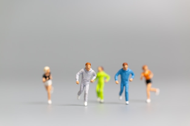 Miniature people Running on gray background and free space for text