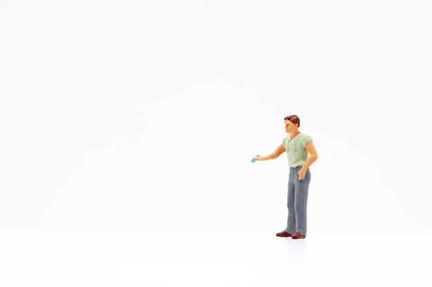 Miniature people standing on white background