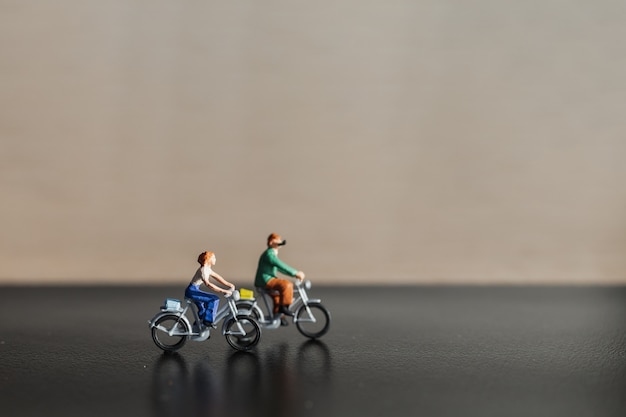 Miniature people: Travelers riding bicycle 