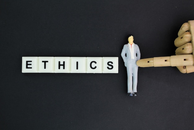 miniature people with the word ethics the concept of ethics in work or ethics in industry