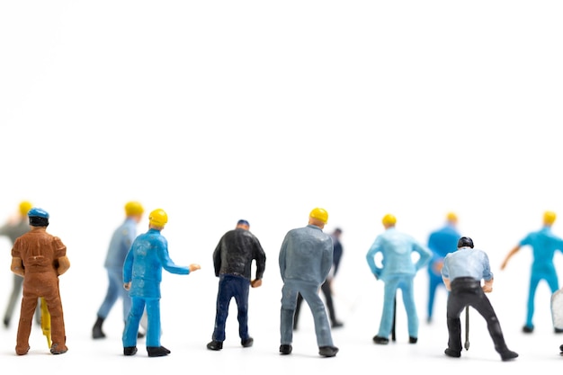 Miniature people Worker team standing on white background Labour day concept