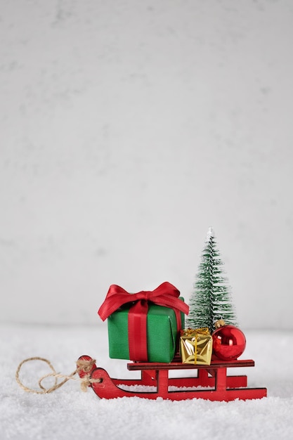 Miniature sledge with Christmas presents ornament and Christmas tree