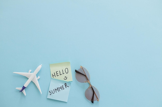 Miniature toy airplane on color background and word hello summer Trip by airplane