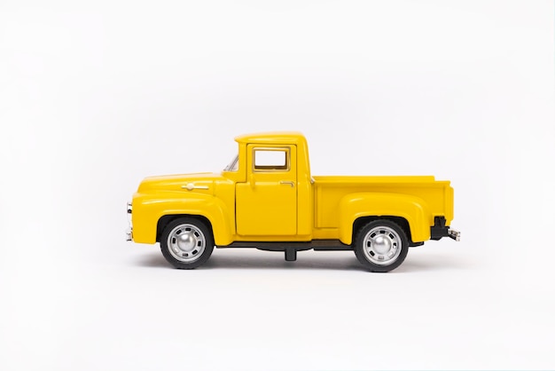 Miniature toy car of yellow color isolated on white background. retro pickup truck.