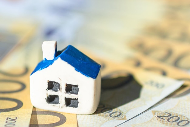 Miniature toy house placed on Euro bill banknotes Concept for real estate costs prices