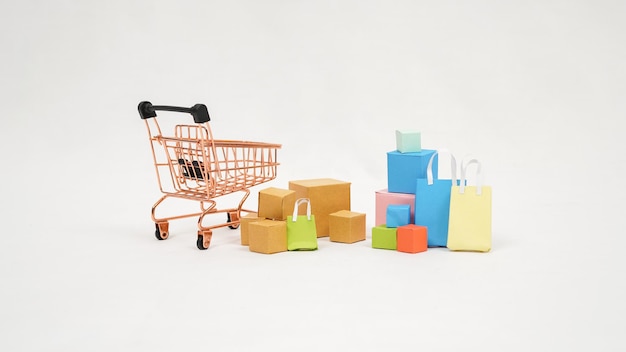 Miniature trolley filled with colorful boxes and mini bags isolated on white background