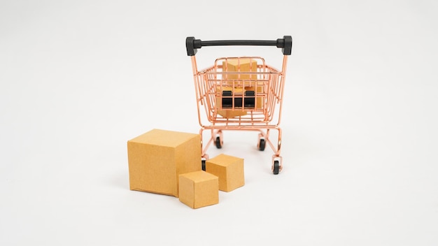 Miniature trolley and stack of brown boxes isolated on white background