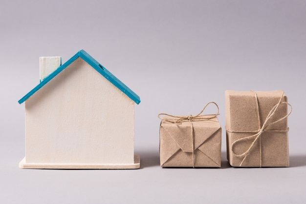 Miniature wooden house, symbol, with boxes, home delivery