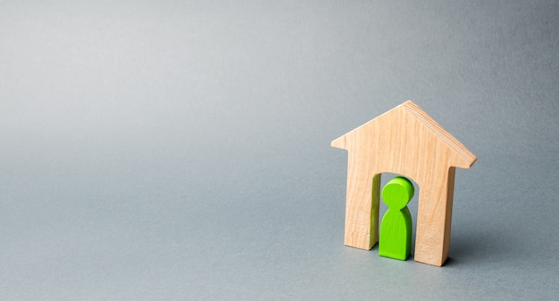 Miniature wooden house with a tenant inside. 