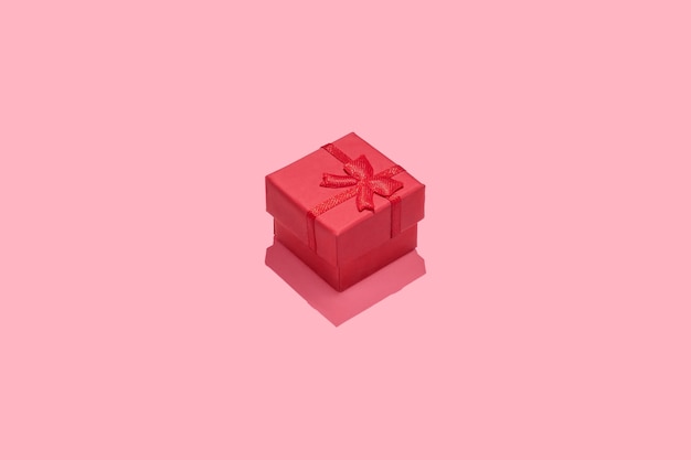 Minimal composition background with red gift box on pink background.