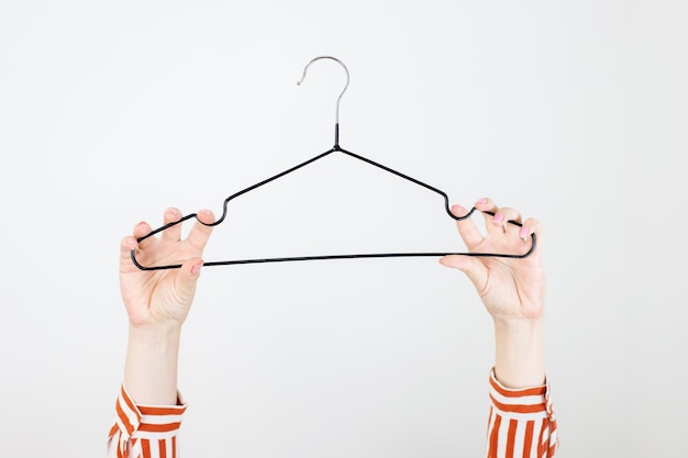 Minimal Fashion stylist or buyer concept nothing to wear cloth hanger and woman hand