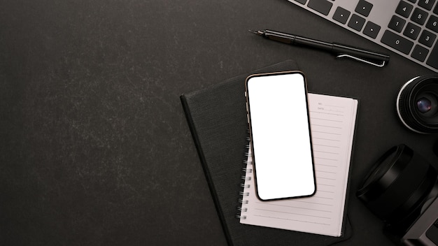 Minimal modern black office desk with work equipments smartphone blank screen mockup and copy space