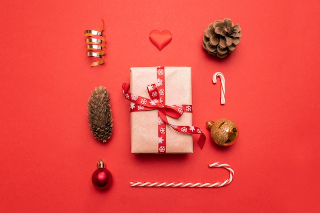 Minimal New Year  of Gift, christmas golden decorations, pine cones on red . Flat lay, top view