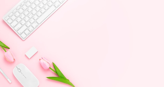 Minimal office desk table with keyboard computer mouse white pen tulip flowers eraser