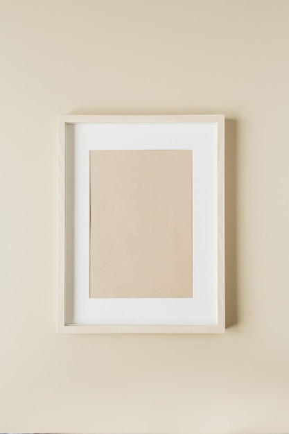 Minimal painting in photo frame on beige wall. Modern interior design concept.