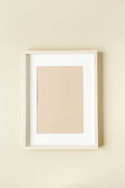 Minimal photo frame on beige wall. Modern interior design concept