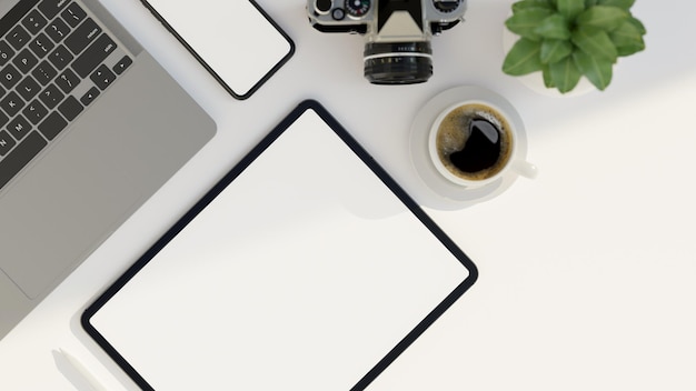 Minimal white office desk workspace with tablet screen mockup laptop camera phone and decor