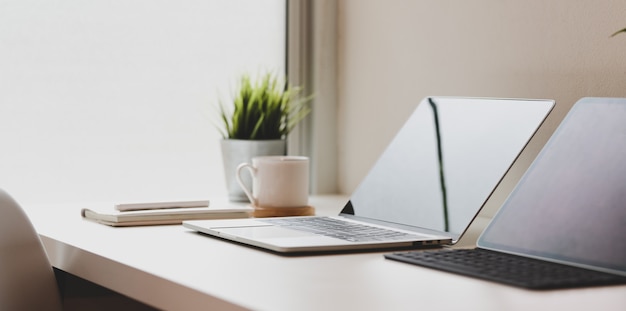 Minimal workplace with open laptop computer with coffee cup 