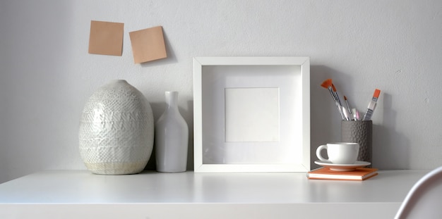 Minimal workspace with frame and copy space with ceramic vase decorations 