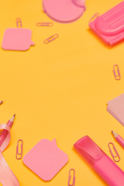 Minimalism back to school concept pink school supplies on yellow background flat lay copy space