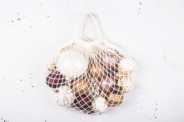 Minimalism and eco-friendly Christmas tree decor - shiny balls in a cotton string bag.