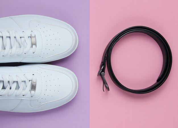 Minimalism fashion. White sneakers, leather belt. Top view