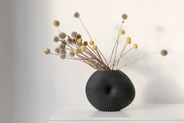 Minimalist composition of dried round flowers in ceramic vase as home decoration