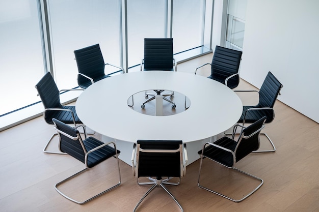 Minimalist conference room with a circular table and black chairs