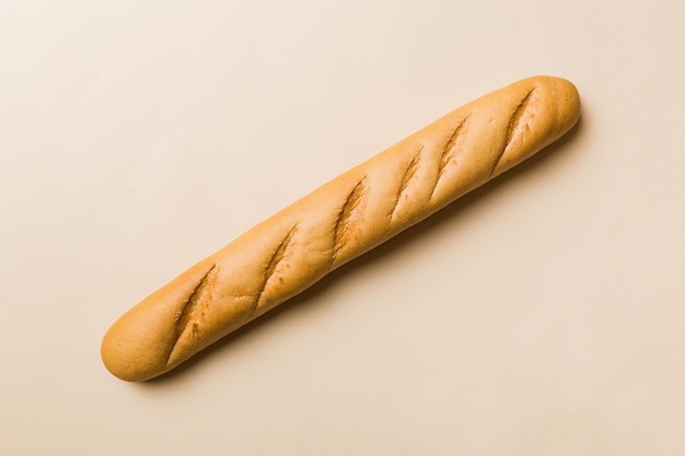 Minimalist french baguette on colored background fresh bread as background top view with space for your text or design