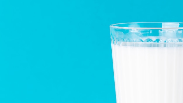 Minimalist glass of milk and blue background with copy space