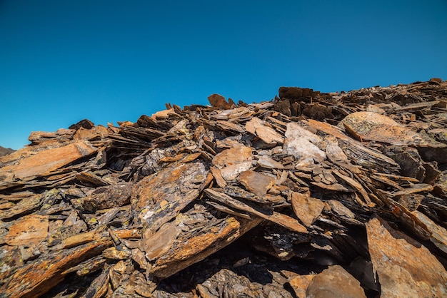 Minimalist mountain landscape with old sharp stones in sunlight Minimal alpine scenery with stone outliers under blue sky in sunny day Simple mountain minimalism with old sharp rocks in sunshine