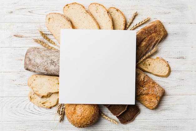 Minimalist paper blank mockup on background of Types of homemade bread Different kinds of fresh bread as background top view with space for your text or design