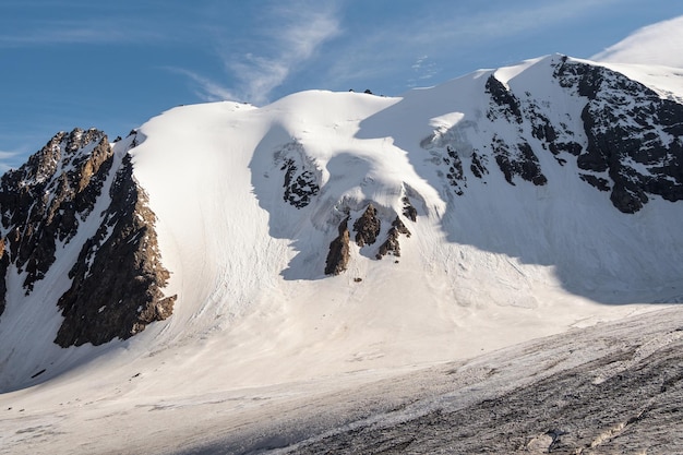 Minimalist snow mountain landscape with large glacier in sunlight Simple snowy minimalism with glacial in sunshine Minimal alpine view to snow mountain tops in sunny day