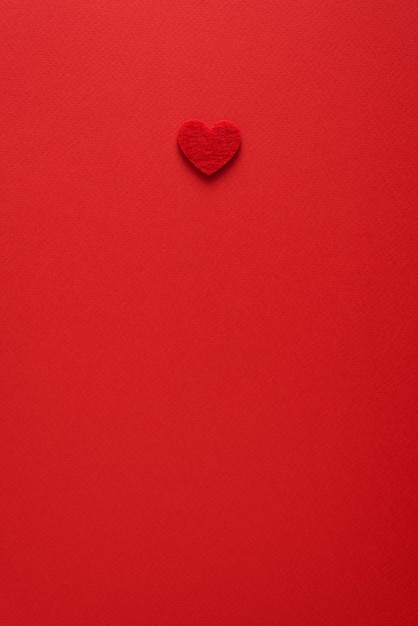 Minimalist Valentines Day background with heart in red color. Flat lay with copy space