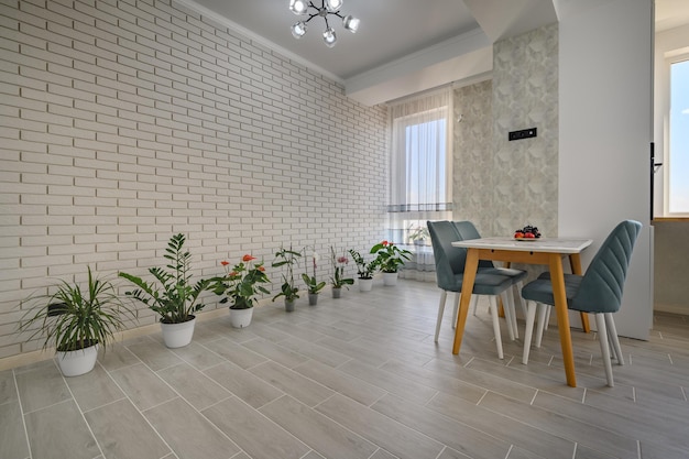 A minimalist white studio with a kitchen and dining table