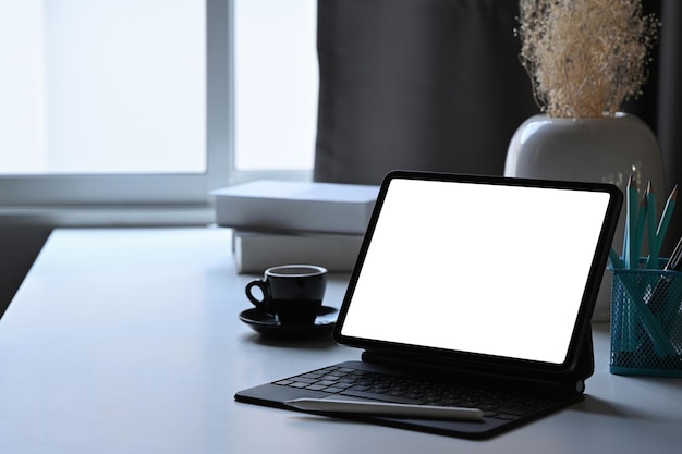 Minimalist workplace with computer tablet coffee cup and stationery