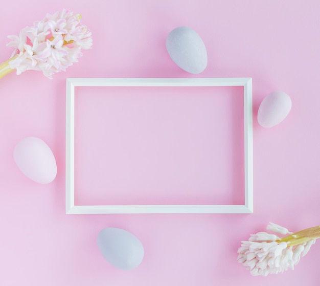 Minimalistic Easter background with pastel colored eggs photo frame and hyacinth flowers on a pink background Easter decoration minimalist design modern design template