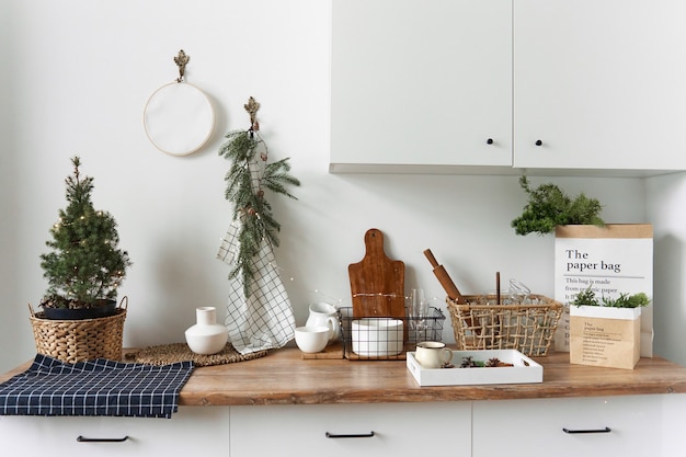 Minimalistic light kitchen interior using pine branches.