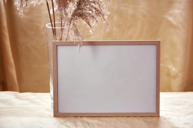 Minimalistic mock up frame with dry flowers decorations Cozy home atmosphere mockup Natural beige background High quality photo