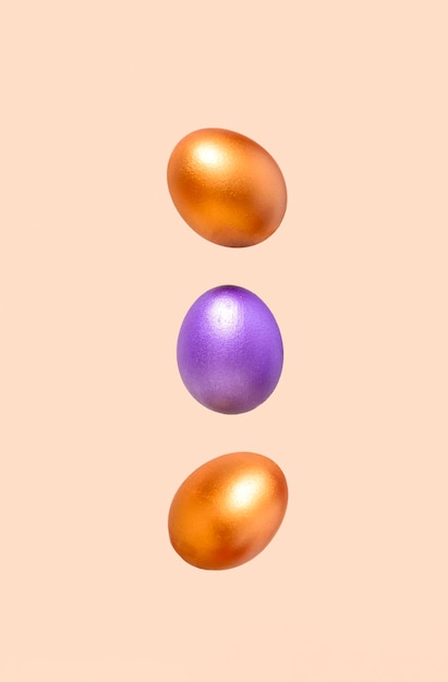 A minimalistic photograph of three flying eggs against a pastel beige background With copy space Vertical FormatxA