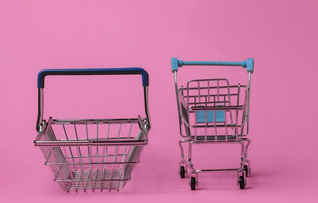 Minimalistic shopping concept. Shopping trolley, basket on pink background.