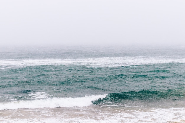 Minimalistic winter seascape in snowy weather